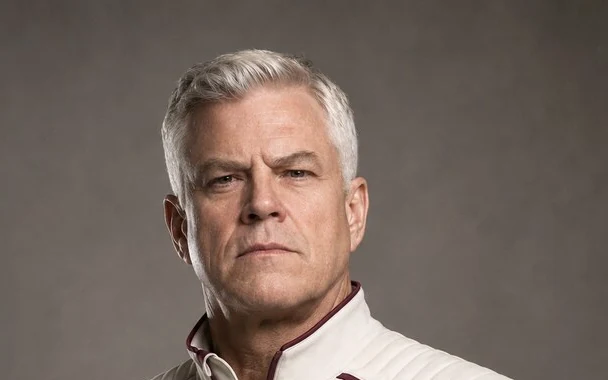 Commander Orrick Dane, a broad silver-haired man in a cream Lamplight uniform